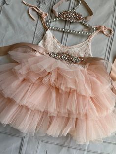 a dress that is on top of a bed with pearls and bows around the waist