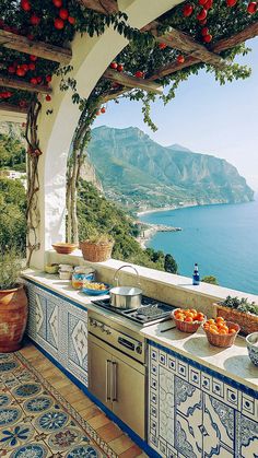 an outdoor kitchen overlooking the ocean and mountains