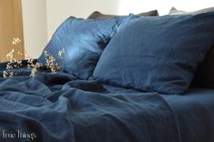 a bed covered in blue sheets and pillows