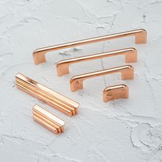 four brass drawer pulls on a white background