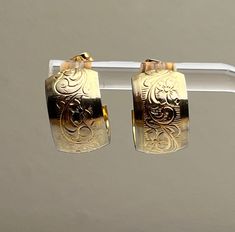 Vintage Small Wide Gold Flower Embossed Hoop Stud Earrings Cute gold tone hoop earrings with embossed flower Plume design.  Small hoops measure 1/2 inch tall and 3/8 inch wide.  Push backs hold firmly.  In excellent vintage condition.  ATTENTION Jewelry Lover Save 15%Today!  Copy and Paste the Link: https://mailchi.mp/6c4f021a85cf/yesterdaysluster To sign up for our email list and receive a code to save 15% on your order. Our Mission: Our mission is to provide unique and beautiful people with unique and beautiful jewelry.    In order to do our part in preserving the planet all of our jewelry is shipped in gift boxes that are eco-friendly - made from recycled materials. Our packing materials are re-used whenever possible. We avoid the use of plastic unless the item dictates the need for bub Use Of Plastic, Earrings Cute, Gold Flower, Gold Flowers, Jewelry Lover, Email List, Jewelry Earrings Studs, Emboss, Beautiful Jewelry