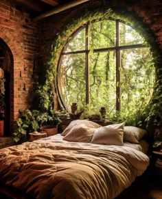 a bed sitting under a large window next to a lush green forest