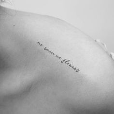 the back of a woman's left shoulder with an inscription on it