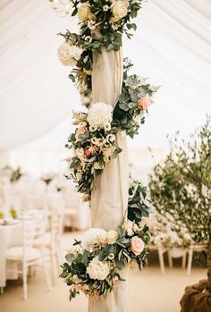 the wedding arch is decorated with flowers and greenery for an elegant touch to the reception