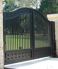 an iron gate is opened to allow people to enter