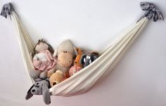 stuffed animals in a hammock hanging on the wall