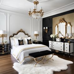 a white and gold bedroom with black furniture