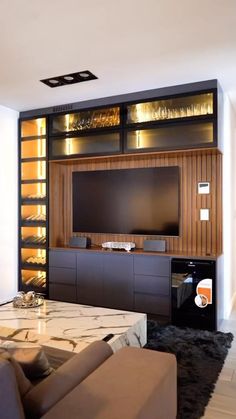 a living room with couches and a large tv on the wall in front of it