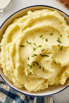 a bowl of mashed potatoes next to a carton of chicken broth