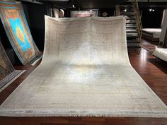 an antique rug is on display in a room with wooden flooring and other items