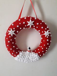 a red and white christmas wreath hanging on a wall