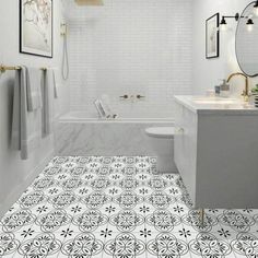 a white bathroom with black and white tile flooring