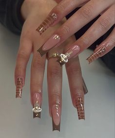 a woman's nails with gold decorations on them and some rings in the middle