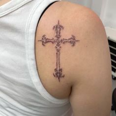 a woman with a cross tattoo on her shoulder