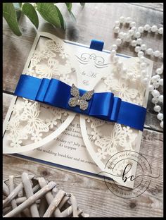 a white and blue wedding card with a bow