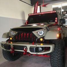 a jeep is parked in a garage with its lights on and the front bumper light turned red