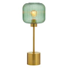 a green glass and brass lamp on a white background