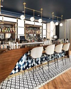 the bar is decorated with white chairs and black patterned upholstered barstools