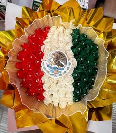 a bouquet of flowers with the flag of mexico in it's center surrounded by gold foil