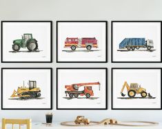 four framed pictures of trucks are on the wall above a toy train and wooden table