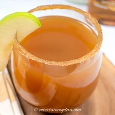 an apple cider is garnished with sugar and sits on a wooden platter