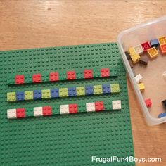 a plastic container filled with legos sitting on top of a wooden floor next to a table