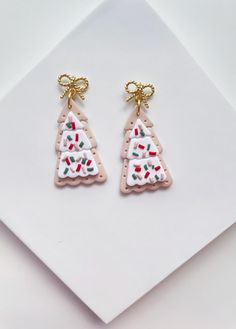 Christmas tree sugar cookie earrings made of polymer clay and 24K gold plated bow studs. Super lightweight! Approximate Length: 1.75 Inches Christmas Polymer Clay Earrings, Cookie Earrings, Christmas Tree Bows, Business Check, Business Checks, Earrings Christmas, Bow Earrings, Christmas Stuff, Jewelry Handmade