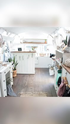 the inside of a camper with lots of storage space and plants on the shelves