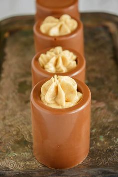 three cups filled with food sitting on top of a tray