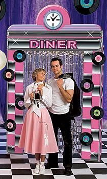 a man and woman standing in front of a photo booth with the words dinner on it