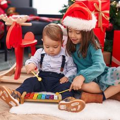 two young children playing with musical instruments on the floor