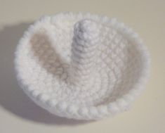 a white crocheted bowl sitting on top of a table