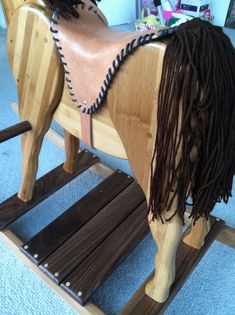 a wooden rocking horse with dreadlocks on it