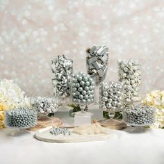 a table topped with lots of candy and candies on top of white cloth covered tables