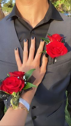 a woman with two red roses on her wrist and one in the other's hand