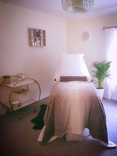 a bed sitting in a bedroom next to a table with a potted plant on it