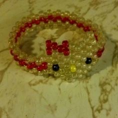 two bracelets with beads and letters on them sitting on a marble counter top next to each other