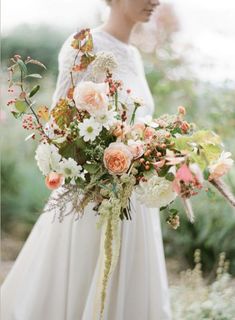 a woman holding a bouquet of flowers in her hand