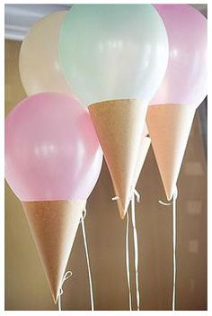 three ice cream cones with balloons attached to them