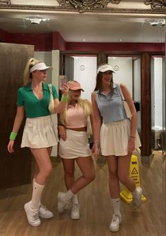 three women in tennis outfits posing for a photo