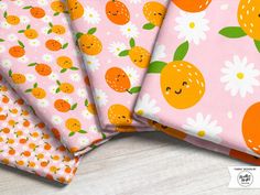 four oranges and daisies printed on pink fabric, with white daisies in the background