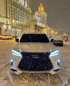 the front end of a white car on a snowy street