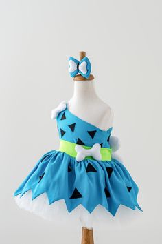 a blue and white dress on a mannequin with a bow in the center