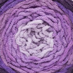 a pile of purple and white towels sitting on top of each other in a circle