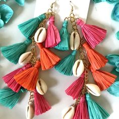 Make a big splash with our multi-color raffia tassel earrings! 🎉 Featuring effortlessly elegant, sleek cowrie shells and vibrant boho-chic tassels, these statement makers are the ultimate beach vibe upgrade. Rock the beachy vibes and turn heads with our multi-color version! 🌈 Let these fabulously chic beachy statement makers tassels sway down to on your shoulders! They're extra-long, pure luxe, lightweight and comfortable.🌴 Features Material: Cowrie Shell and Raffia Drop length: 6.5 inches; w Fringe Earrings For Vacation, Summer Tassel Dangle Earrings With Latkans, Summer Latkans Tassel Dangle Earrings, Summer Tassel Dangle Earrings, Green Fringed Beach Jewelry, Summer Latkan Tassel Dangle Earrings, Beach Earrings With Latkans, Trendy Summer Jewelry With Tassels, Tassel Jewelry For Vacation