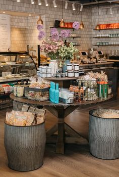 a table that has some baskets on it with flowers in the center and other items around it