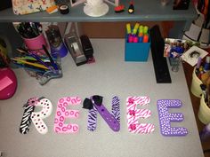 the letters are made out of plastic and have zebra print on them, along with other crafting supplies