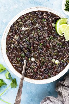 a white bowl filled with black beans and garnished with cilantro