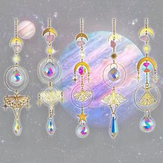 a group of different earrings hanging from strings in front of a space background with stars and planets