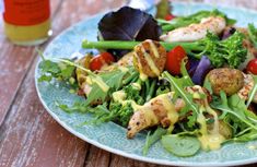 a salad with chicken and vegetables on a blue plate